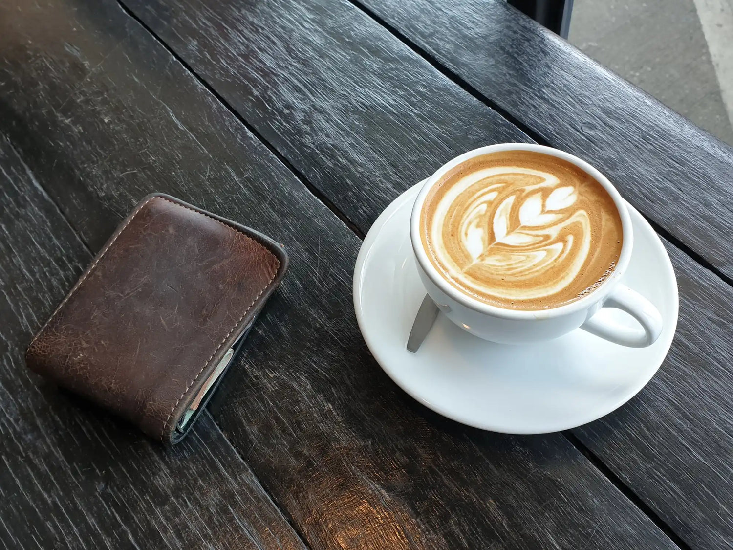 Cup of coffee with latte art in the shape of a leaf pattern.